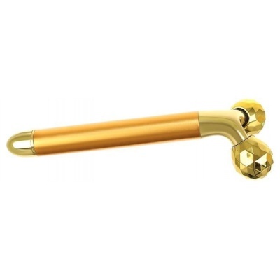 Massageador facial dourado com cabo cilíndrico e duas esferas facetadas.