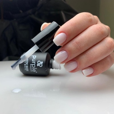 Frasco de verniz para unhas da marca Purple Professional com pincel e unhas pintadas de nude