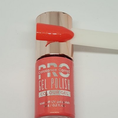 Frasco de verniz em gel cor coral com tampa dourada e amostra da cor