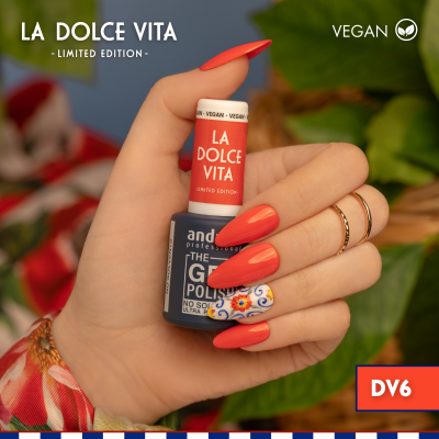 Frasco de verniz LA DOLCE VITA em mão feminina com unhas vermelhas e decoração floral