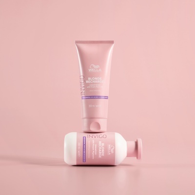 Produtos cosméticos Wella Blonde Recharge em embalagens rosa sobre fundo rosa