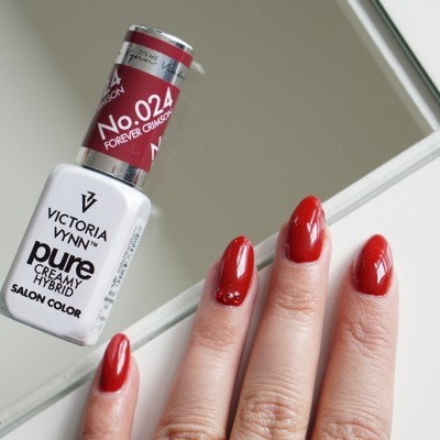 Garrafa de esmalte vermelho Victoria Vynn com unhas pintadas da mesma cor