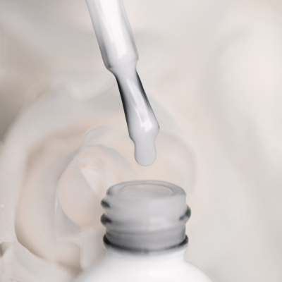Frasco aberto de verniz branco para unhas com conta-gotas a pingar, fundo creme, texto SAUTE NAILS