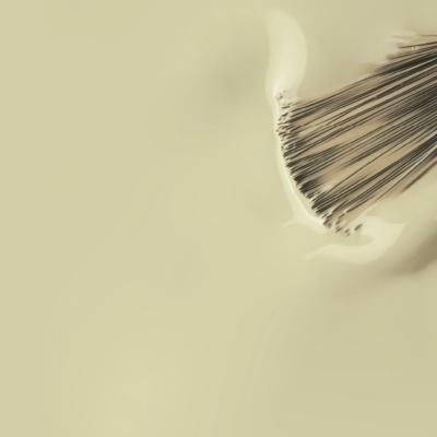 pincel de maquilhagem com cerdas castanhas em superfície líquida cremosa