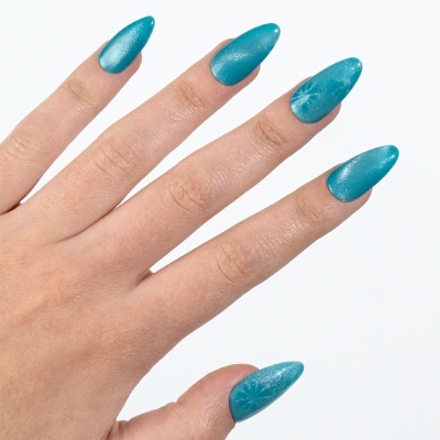 Mão com unhas postiças azuis cintilantes com padrão de estrelas