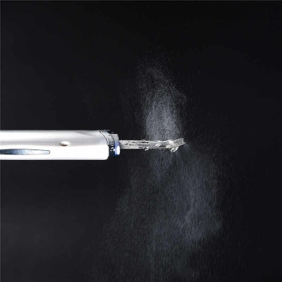 Escova de dentes elétrica branca e cinza a libar vapor ou névoa com fundo preto