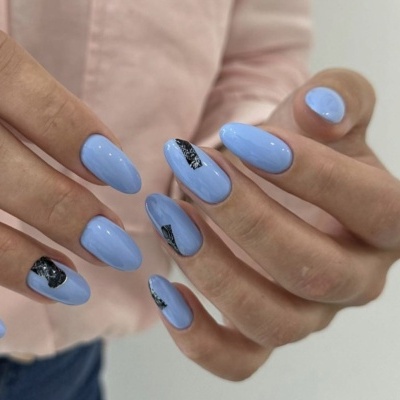Unhas ovais pintadas de azul claro com detalhes pretos brilhantes