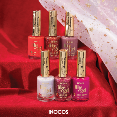 Cinco frascos de verniz Inocos like gel em várias cores sobre tecido vermelho com decoração de tecido branco com estrelas douradas.