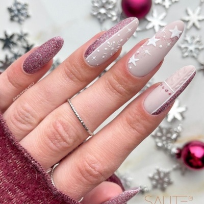 Unhas artificiais decoradas em tons rosa e nude com padrões natalícios