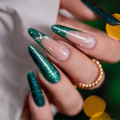 Unhas compridas com esmalte verde glitter e decoração branca com padrão de estrela e aranha.