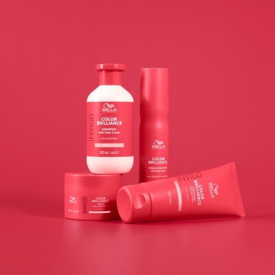 Produtos capilares Wella Invigo Color Brilliance em embalagens vermelhas e brancas sobre fundo vermelho