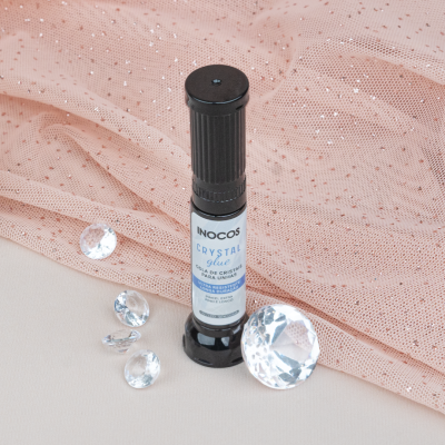 Cola para unhas INOCOS CRYSTAL glue com pedras transparentes sobre tecido rosa