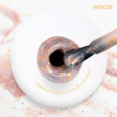 Frasco branco de verniz de unhas INOCOS com verniz castanho leitoso e flocos dourados