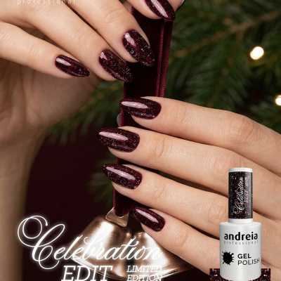 Unhas com verniz gel bordô brilhante da Andreia Professional, edição limitada CE6, segurando sino dourado com fita de veludo.