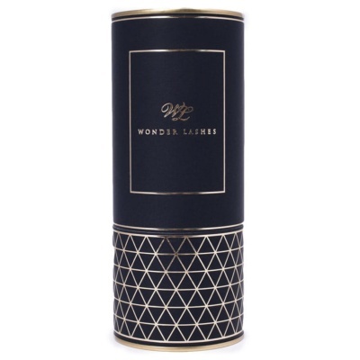 Embalagem cilíndrica preta e dourada com padrão geométrico e texto Wonder Lashes