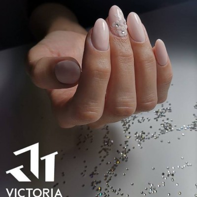 Unhas pintadas com verniz rosa claro e decoração de cristais