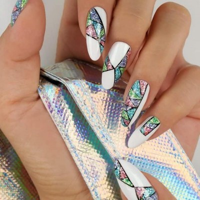 Unhas decoradas com padrão geométrico colorido e fita holográfica