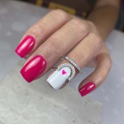 Mão com unhas esmaltadas vermelho e branco com coração rosa