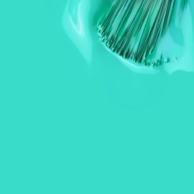 Pincel aplicando tinta verde água.