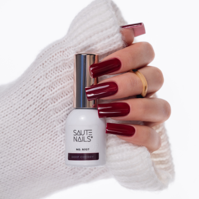 Mão com unhas bordô segurando verniz SAUTE NAILS Deep Cherry