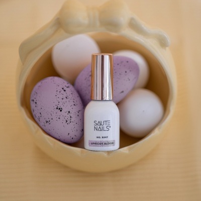 Frasco de verniz de unhas em taça com ovos brancos e lilás com manchas pretas