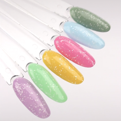 Amostras de verniz para unhas em várias cores suaves com brilhos sobre paletas transparentes