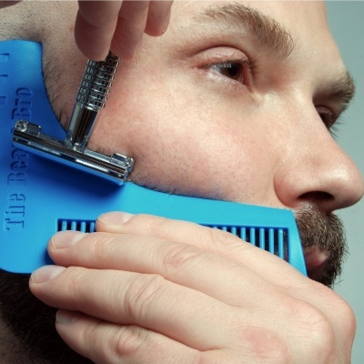 Homem a aparar barba com pente azul 'The Beard Bro' e navalha