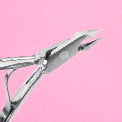 Alicate de corte metálico prateado com lâminas afiadas em fundo rosa