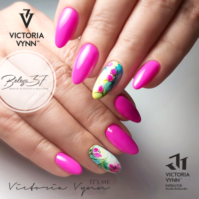 Unhas com verniz rosa vibrante e design floral colorido no dedo anelar.