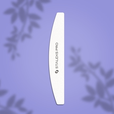 Lima de unhas branca curva STALEKS PRO sobre fundo lilás com sombras de folhas