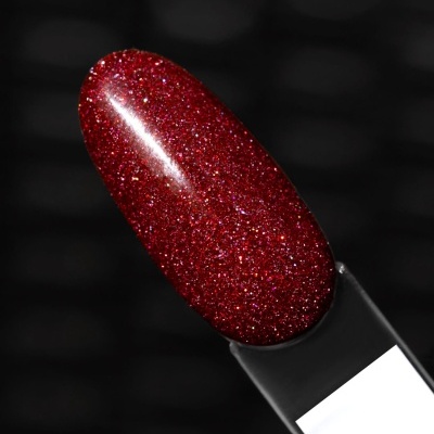 Amostra de verniz de unhas vermelho com glitter sobre fundo escuro