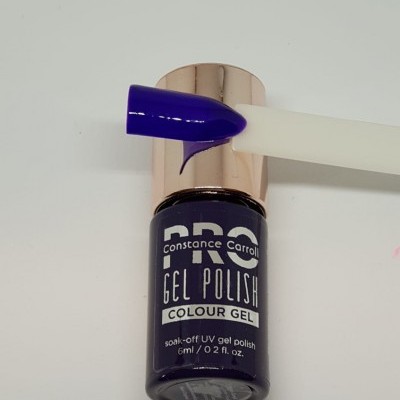 Esmalte gel azul escuro Constance Carroll PRO em frasco pequeno com tampa dourada e amostra da cor num suporte branco