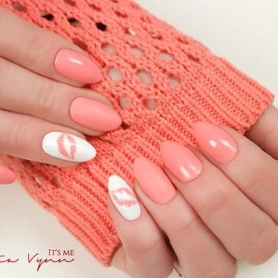 Unhas decoradas em coral e branco com desenho de lábios e manga de malha coral
