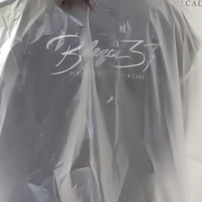 Pessoa com capa plástica transparente com texto Beleza 37 & Care