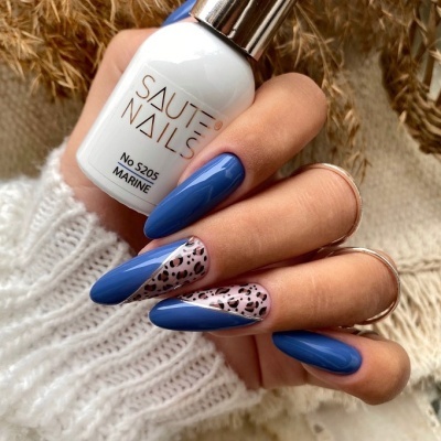 Mão com unhas longas azuis e padrão animal segurando frasco de verniz branco