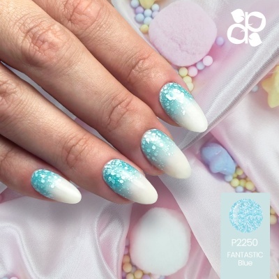 Unhas decoradas em degradê azul claro para branco com glitter sobre tecido rosa