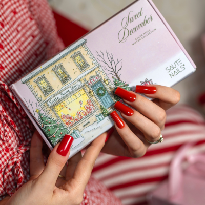 Caixa de vernizes para unhas Saute Nails Sweet December com ilustração de loja e unhas vermelhas.