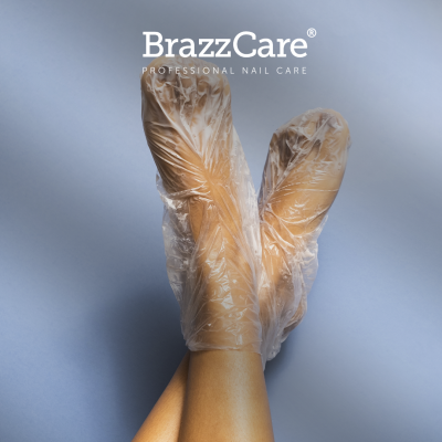 Pés com meias descartáveis transparentes e texto BrazzCare PROFESSIONAL NAIL CARE
