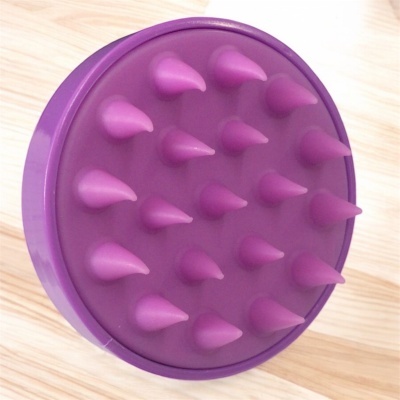 Escova redonda roxa com pinos cônicos, sobre superfície de madeira