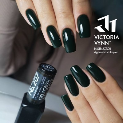Unhas com verniz gel verde escuro e frasco de verniz gel em fundo neutro.