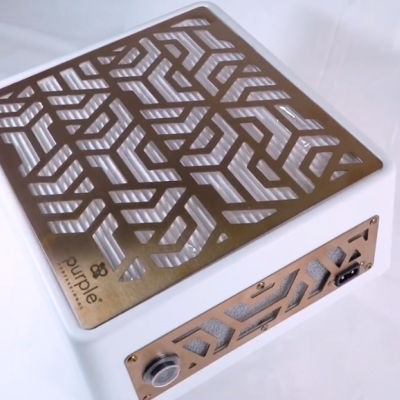 Equipamento eletrónico branco com painel superior decorativo em metal dourado