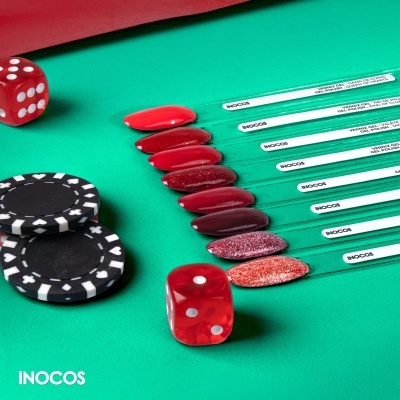 Amostras de verniz vermelho com dados e fichas de poker sobre fundo verde