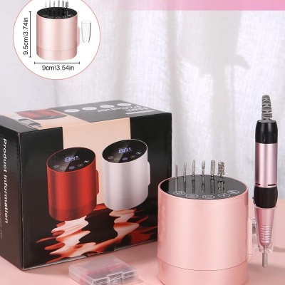 Aparelho elétrico rosa com brocas metálicas e cabo espiral, caixa transparente e embalagem ao fundo.