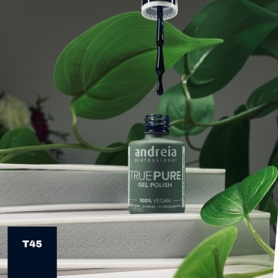 Frasco de verniz gel verde com pincel a pingar, em ambiente com folhas verdes.