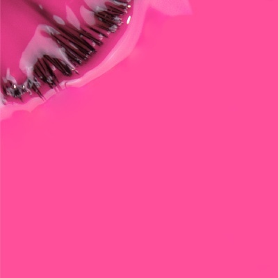 Batom rosa cremoso com contorno preto sobre fundo rosa