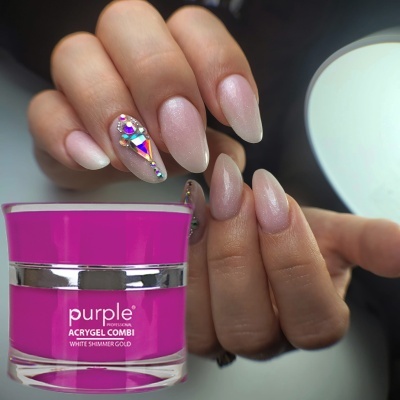 Unhas decoradas com pedras e verniz rosa perolado segurando frasco de gel para unhas roxo e prateado
