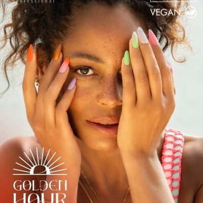 Mulher com unhas multicoloridas em tons pastel, com cabelo cacheado e roupa rosa clara.