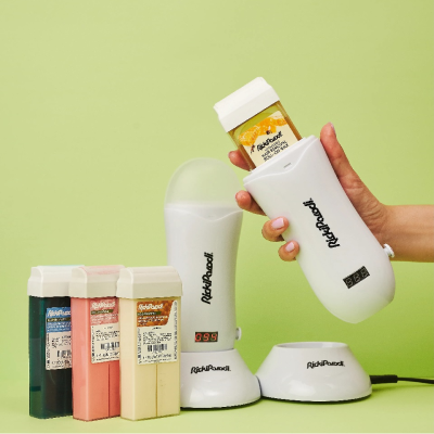 Conjunto de depilação com aquecedor de cera e recargas sobre fundo verde