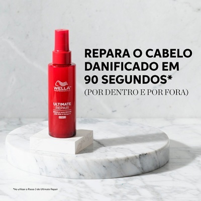 Frasco de spray capilar vermelho Wella Ultimate Repair em pedestal de mármore