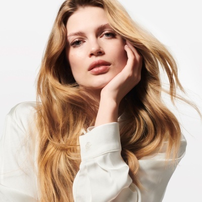 Mulher loira com camisa branca em fundo branco